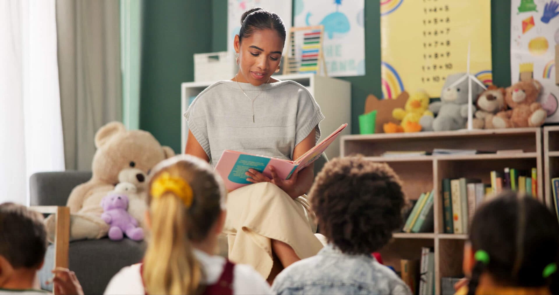 A teacher reading a book to children