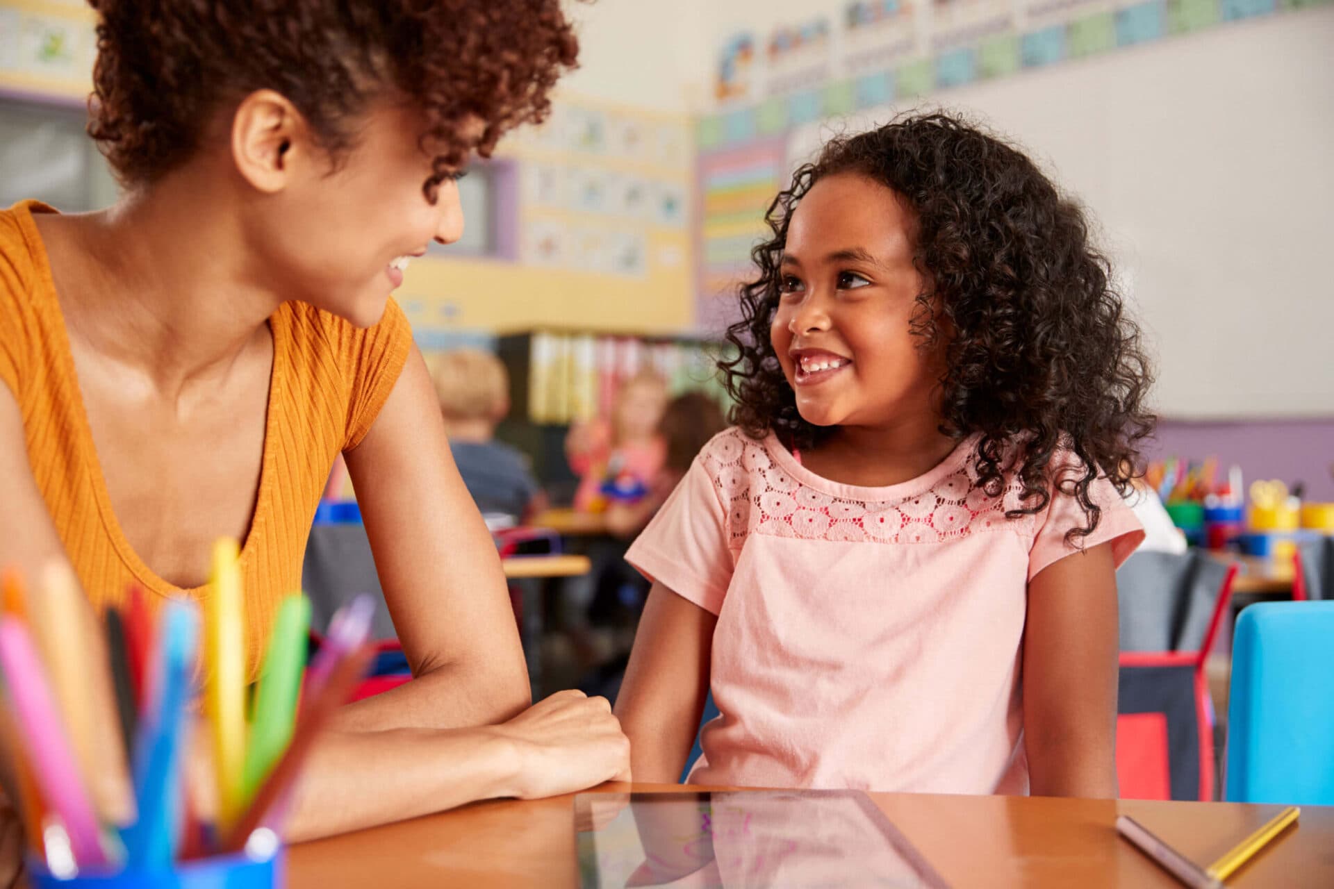 A teacher and a child smiling at each other in a Wee Discover classroom