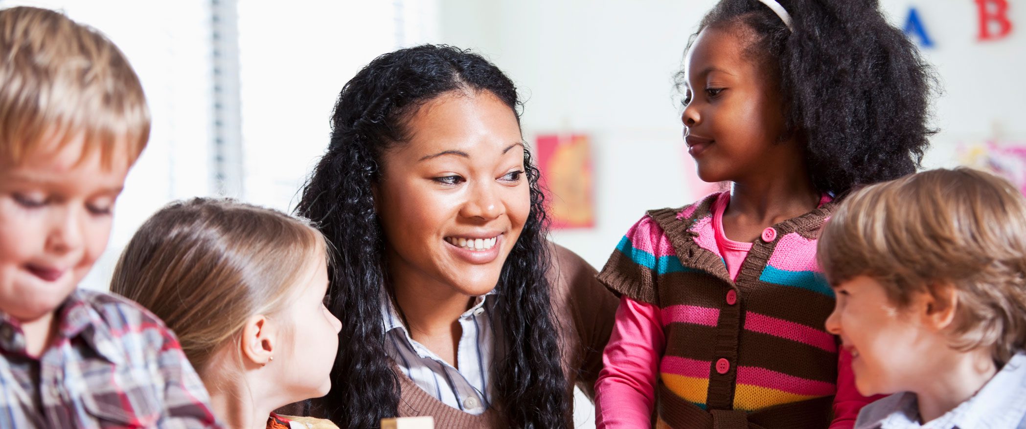 Teacher with group of students smiling and laughing.